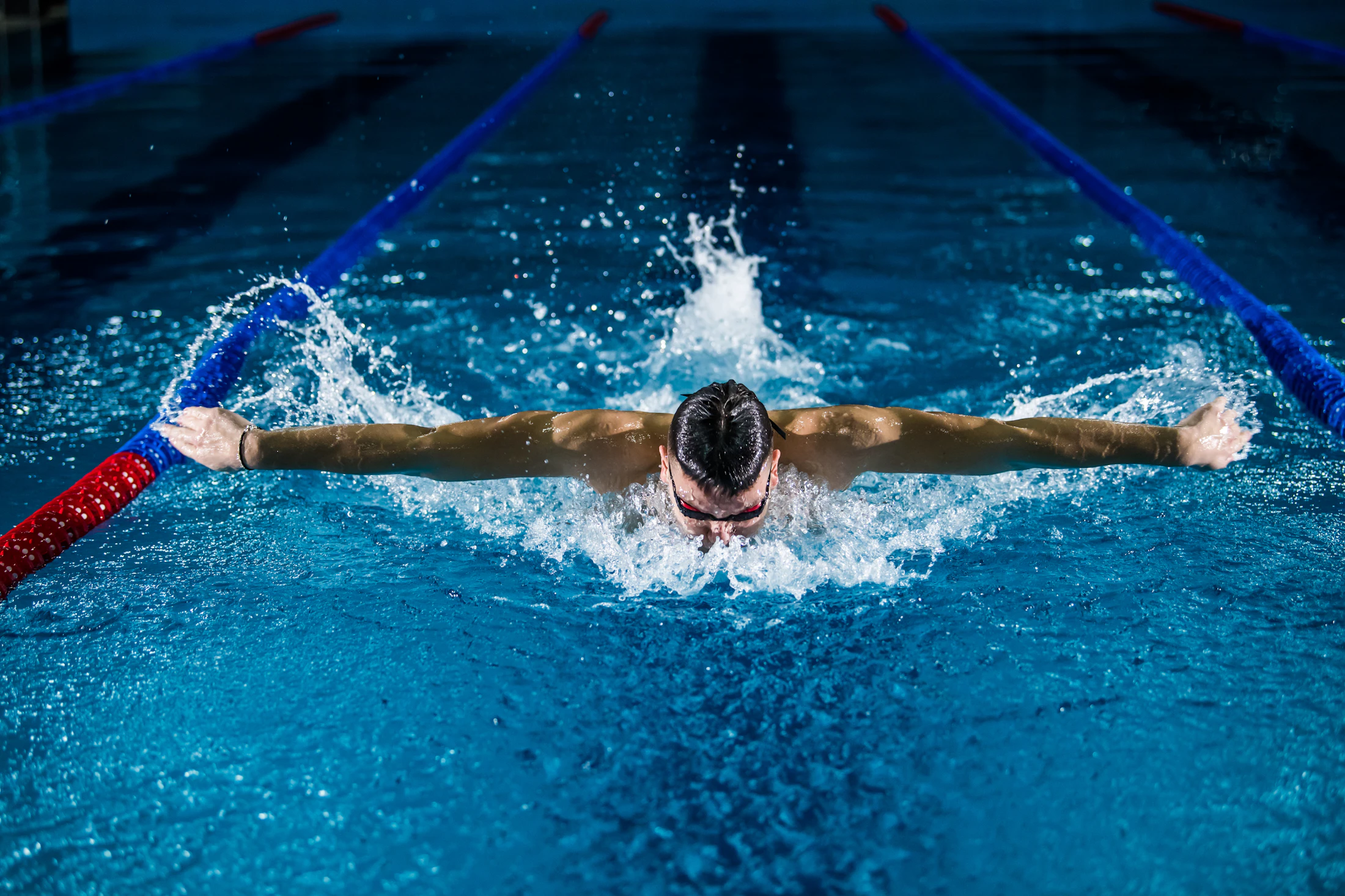 A swimmer mid-stroke in a pool lane