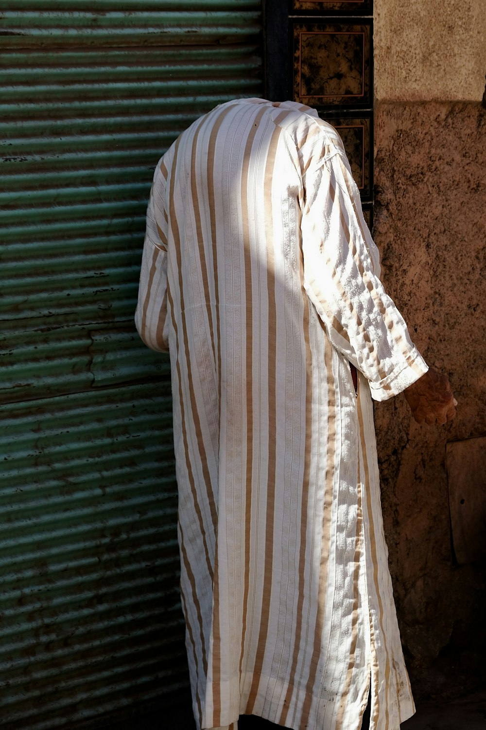 man standing beside green roll-up door