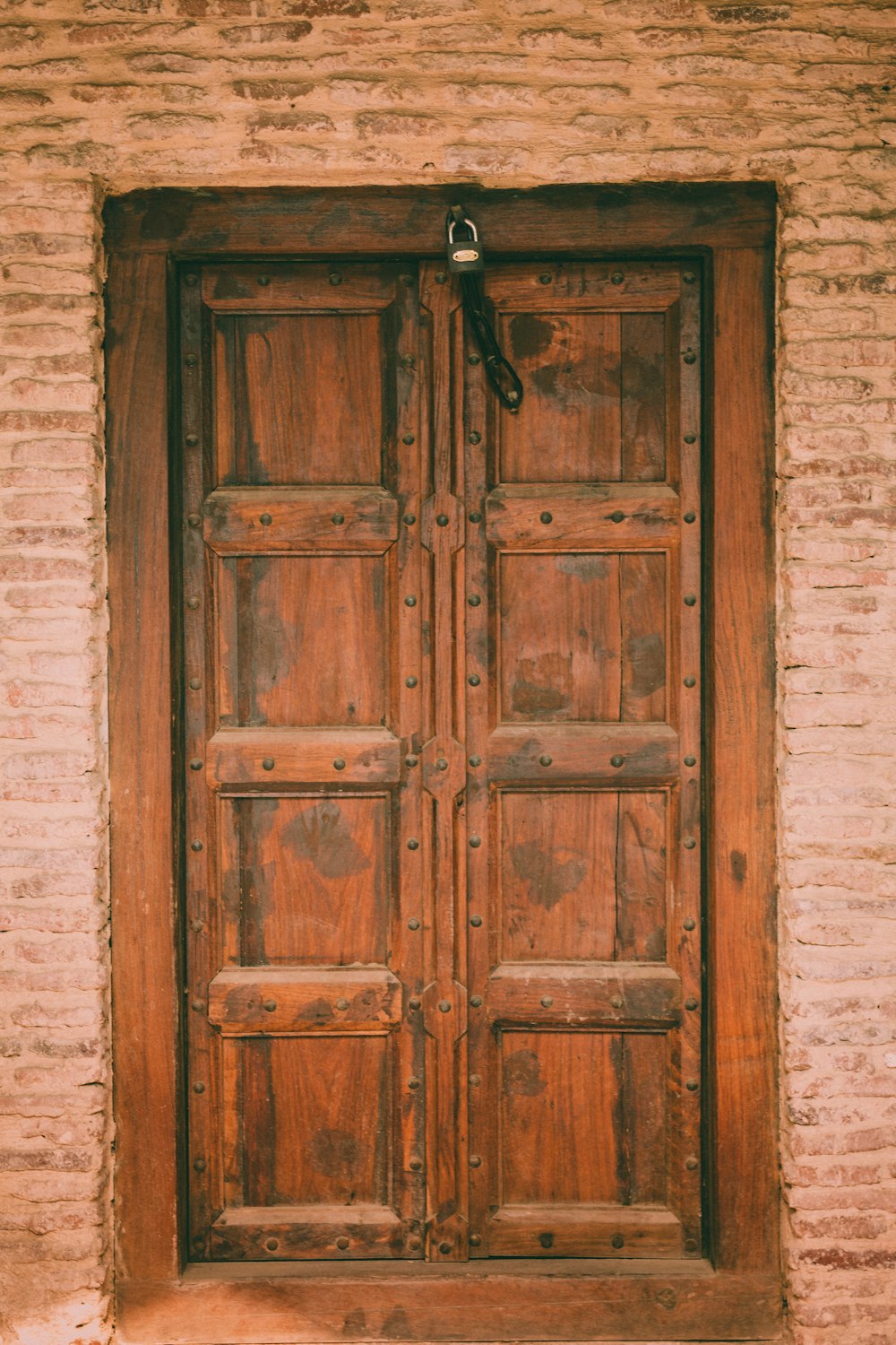 brown wooden door with padlock