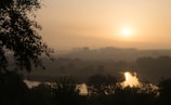 A peaceful landscape showcasing a sunrise over a city.