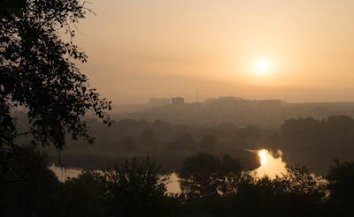 A peaceful landscape showcasing a sunrise over a city.