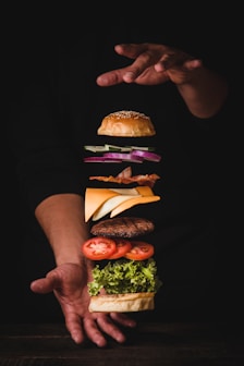 timelapse photo of man holding burger