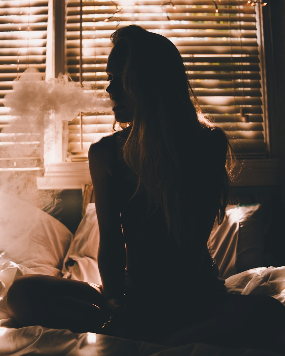 Woman sitting on bed photo – Free Cigarette Image on Unsplash
