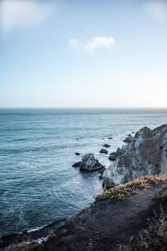 body of water beside rocks