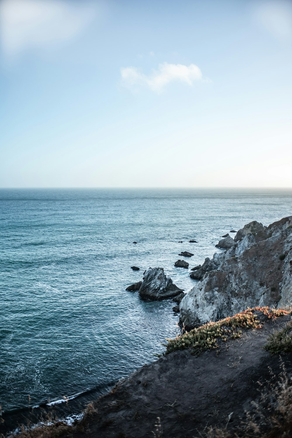 body of water beside rocks