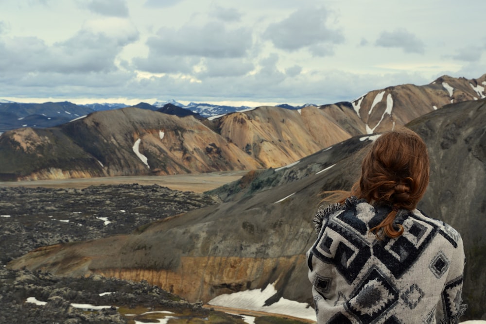 woman facing the mountain ranges