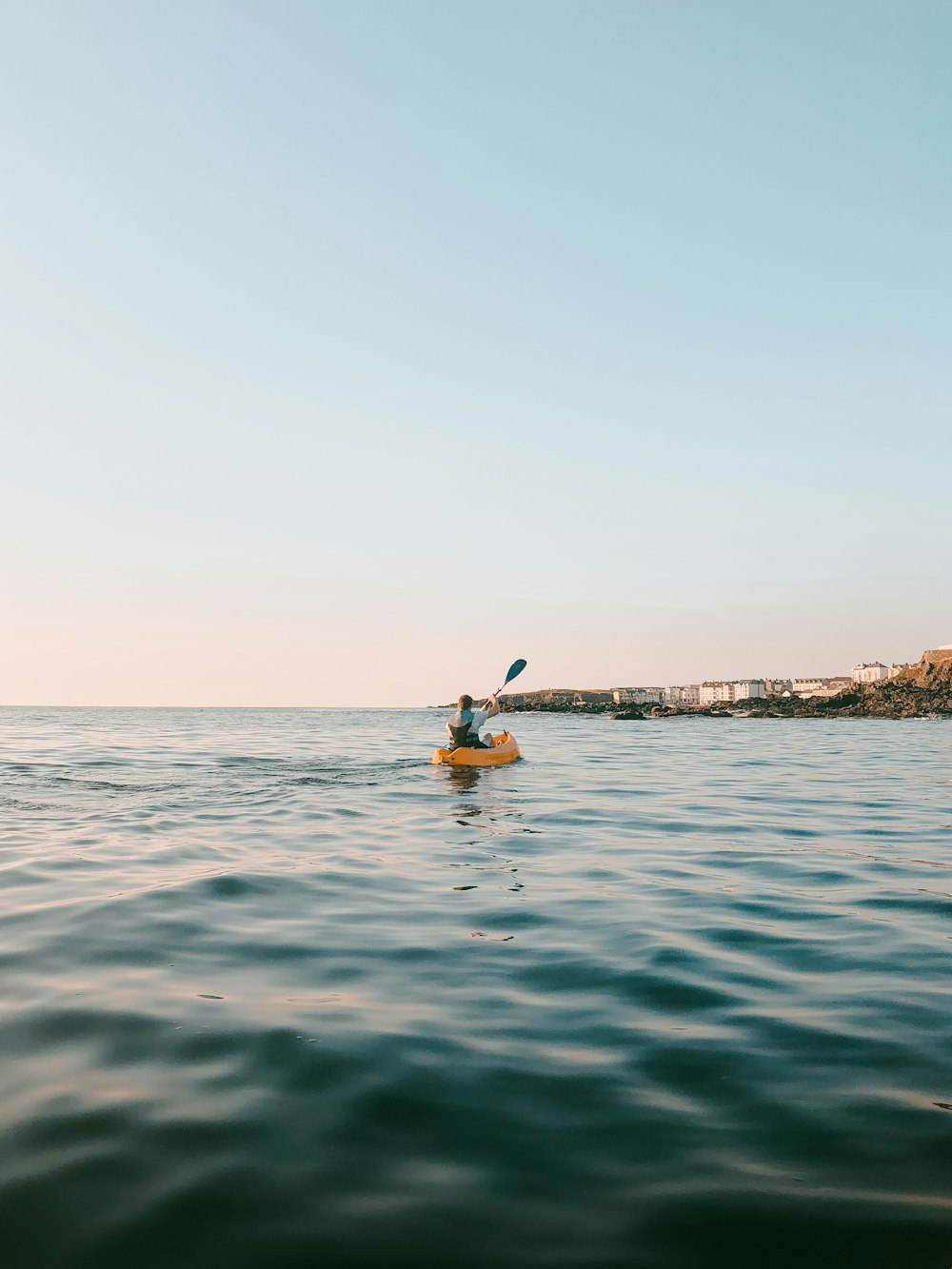 person paddling boat on body of water during daytime