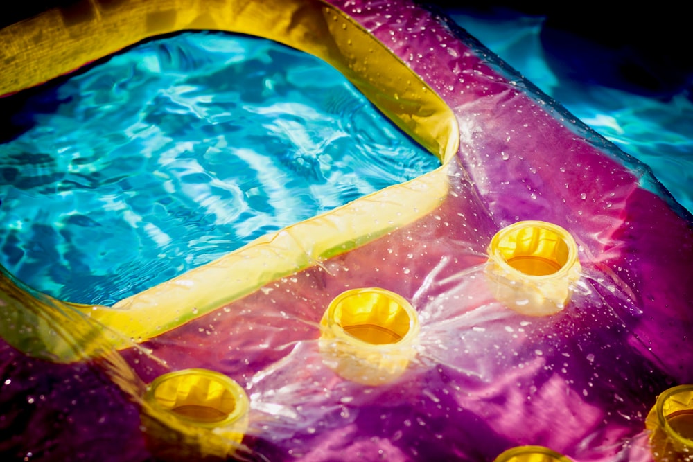 pink and yellow inflatable raft on pool