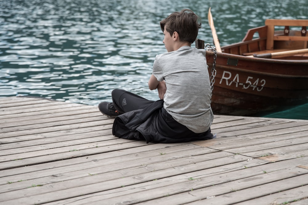 boy sitting on dock