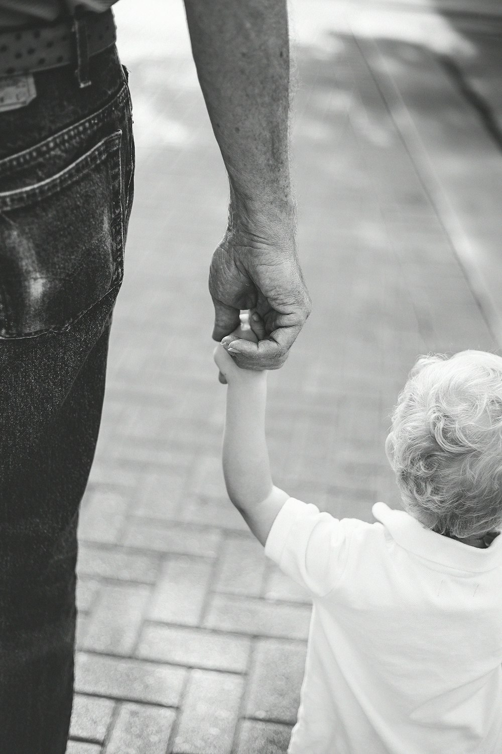 boy holding hands with person on road