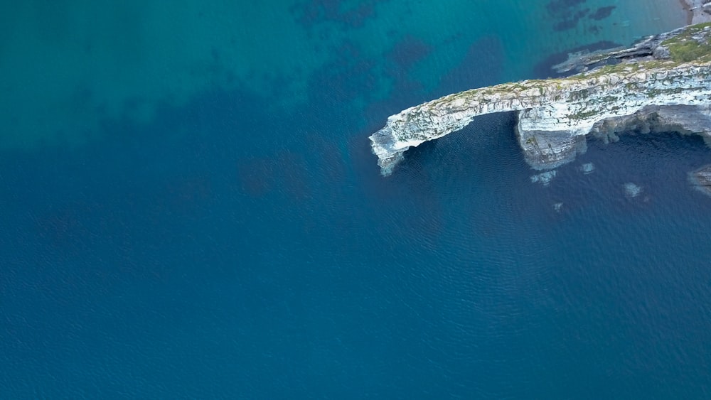 rock formation on water in aerial view