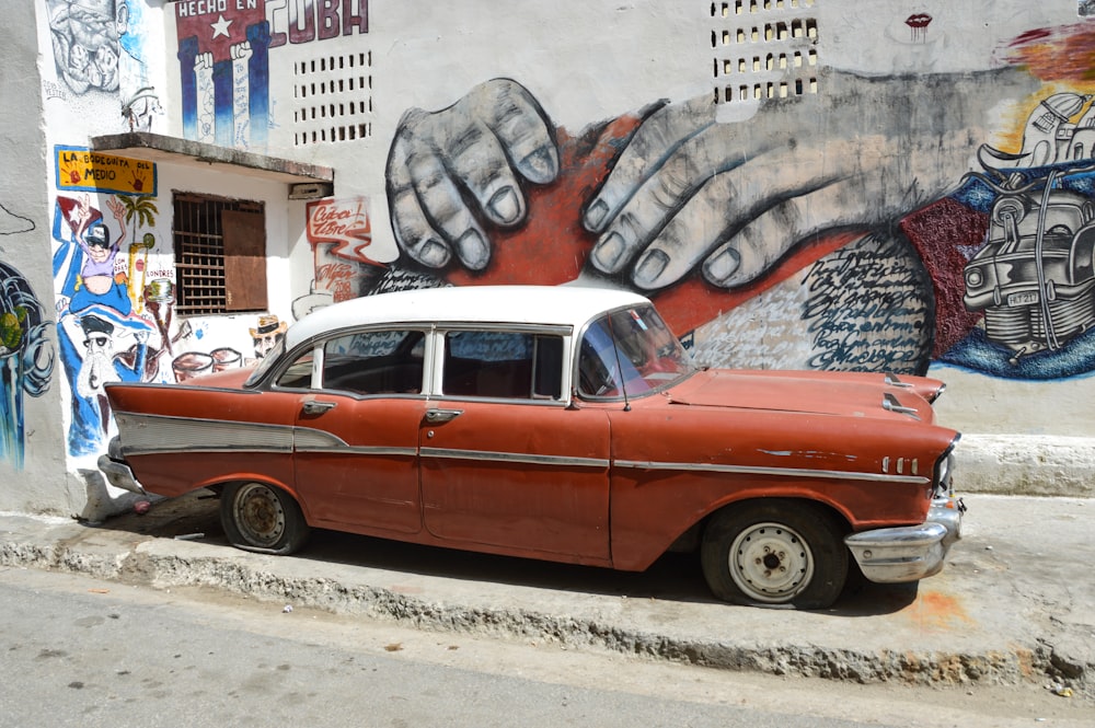 Weiß-rote Limousine in der Nähe der Wand mit Wandgemälde geparkt