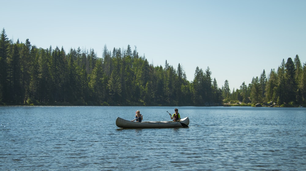 two persons on canoe during daytime