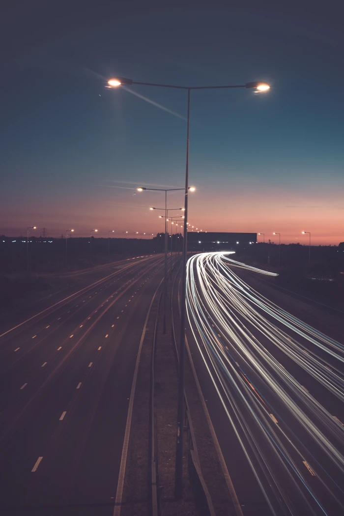 Illuminated street lights along a road at night