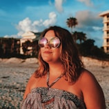 Lifestyle image of a woman wearing a classic black scrunchie while enjoying an Australian beach sunset.