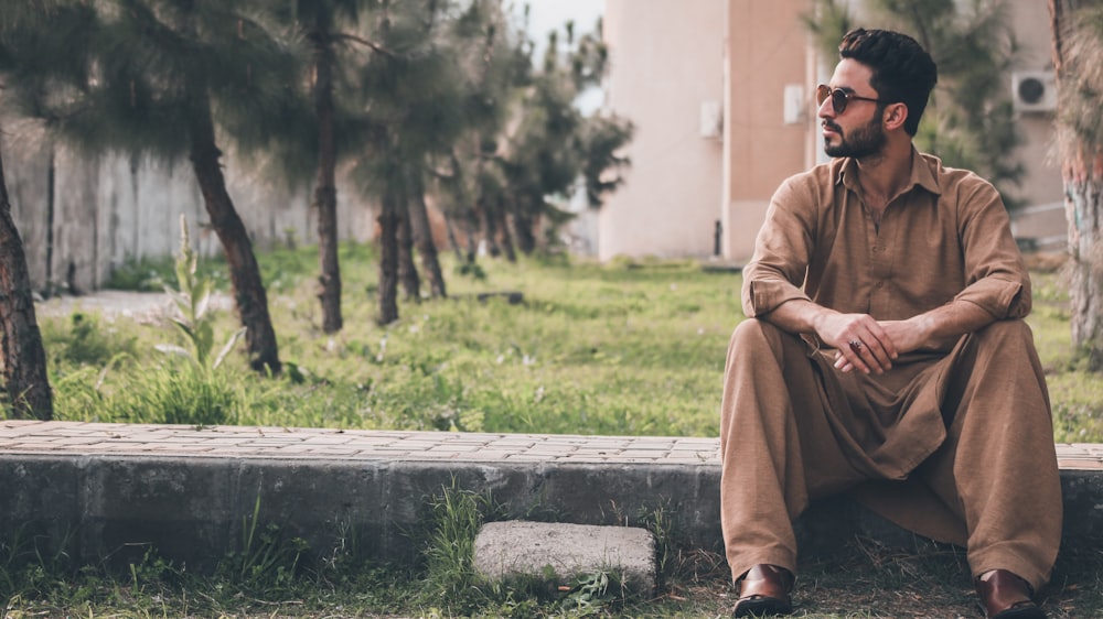 man sitting on concrete gutter