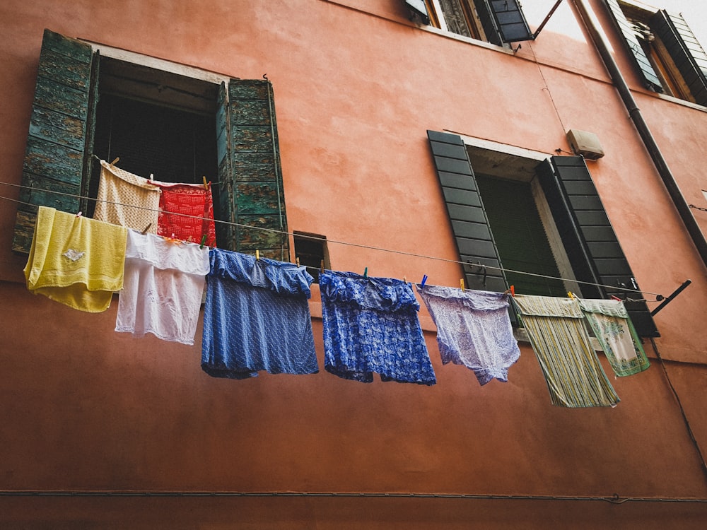 assorted clothes hanged near building