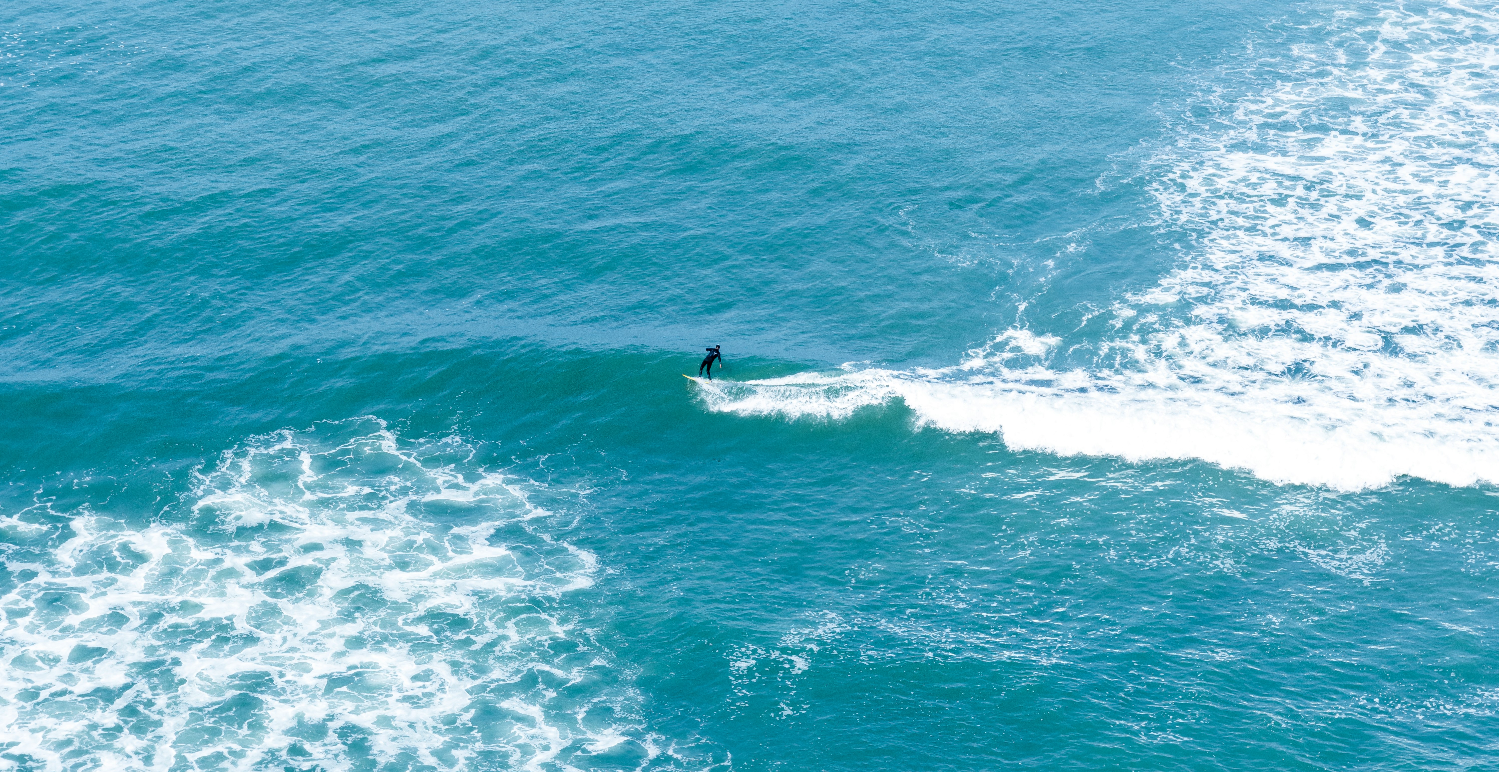 man surfing on body of water during daytime