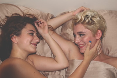 two women laying on bed