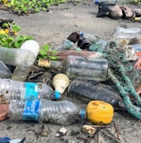 assorted garbage bottles on sandy surface