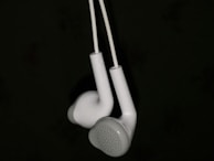 Pearl-white headphones resting on a cobalt-blue stand, highlighting ergonomic design.
