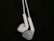 A pair of white earphones suspended against a dark background, showcasing their intricate design and smooth texture.
