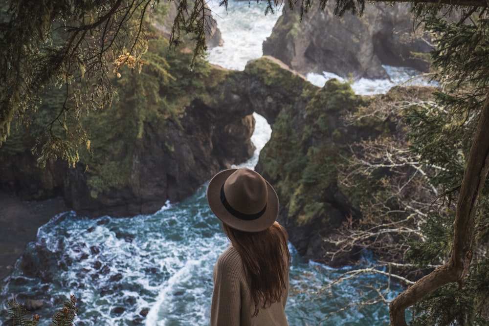 woman in brown hat above body of water during daytime