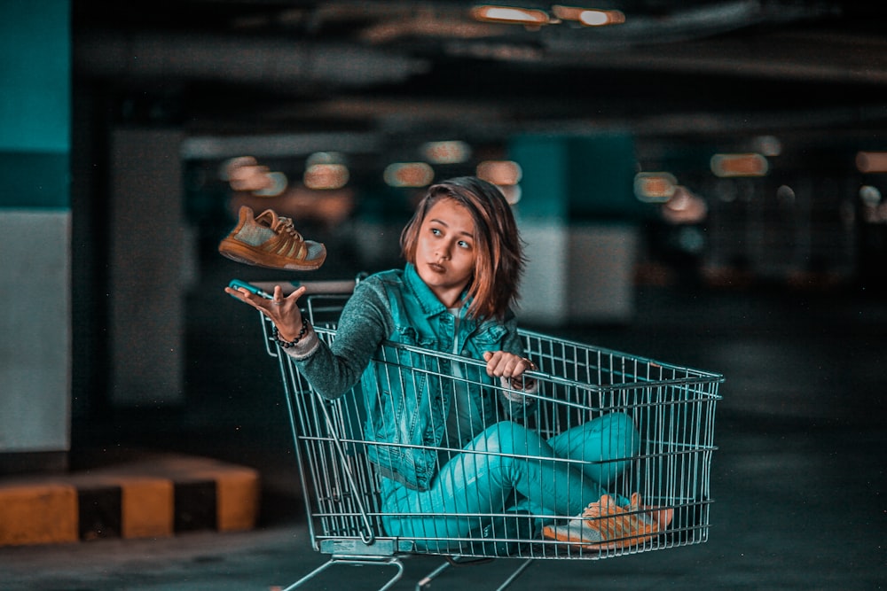 Mujer sentada en tarjeta de compras gris