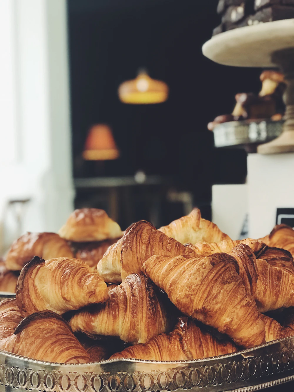 Freshly baked golden croissants cooling on a rack