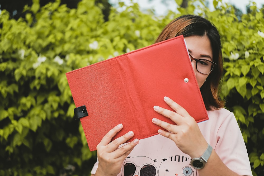 femme tenant une tablette avec une couverture orange