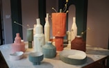 Artistic 3D printed vases with organic shapes displayed on a wooden table.