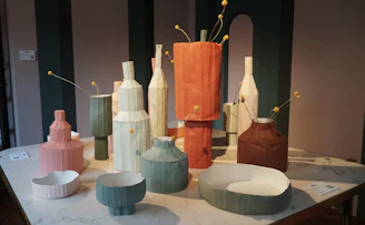 Close-up of a colorful 3D printed geometric vase on a wooden table.