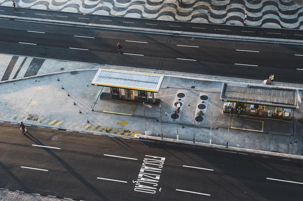 aerial photo of man walking across road approaching store