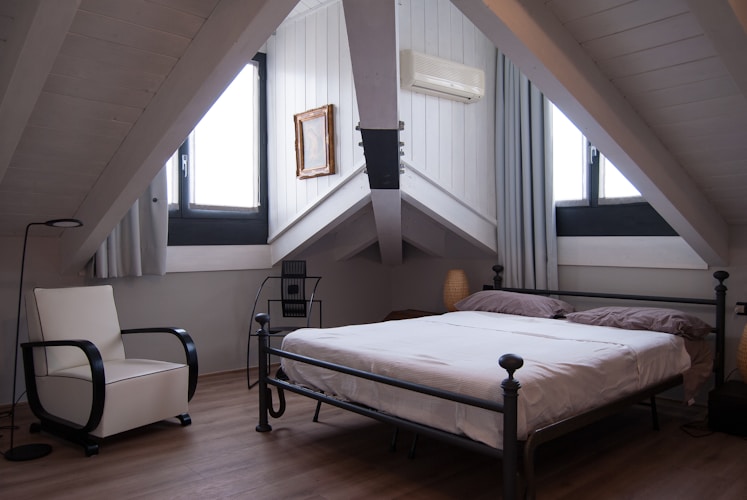 Gepolstertes Bett mit hohem Kopfteil und Nachttischen