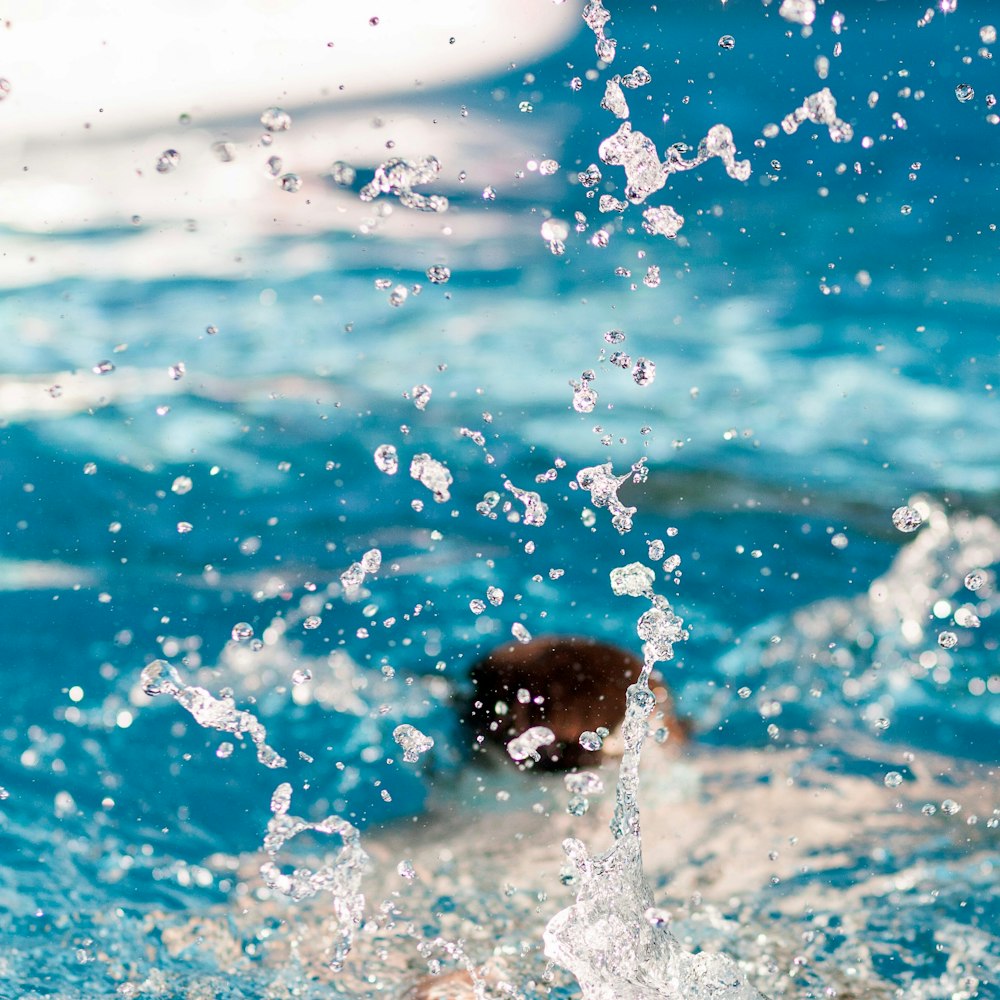 pessoa mergulhando na piscina salpicando água