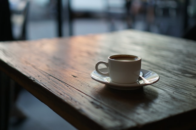 A warm cup of coffee on a rustic wooden table.