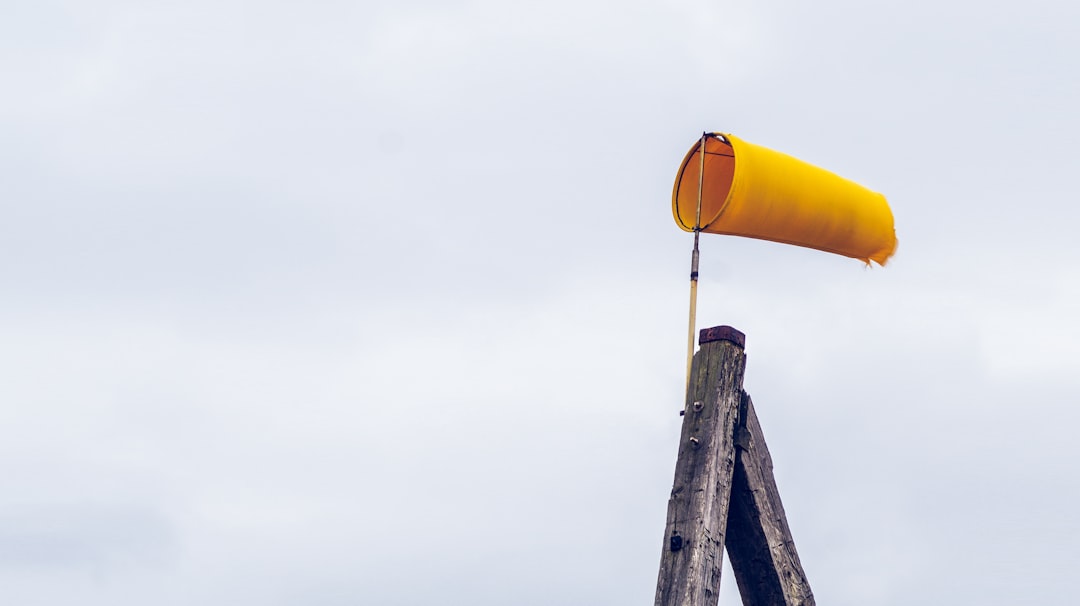 yellow air lantern on brown wooden post, yellow windsock at the beach
