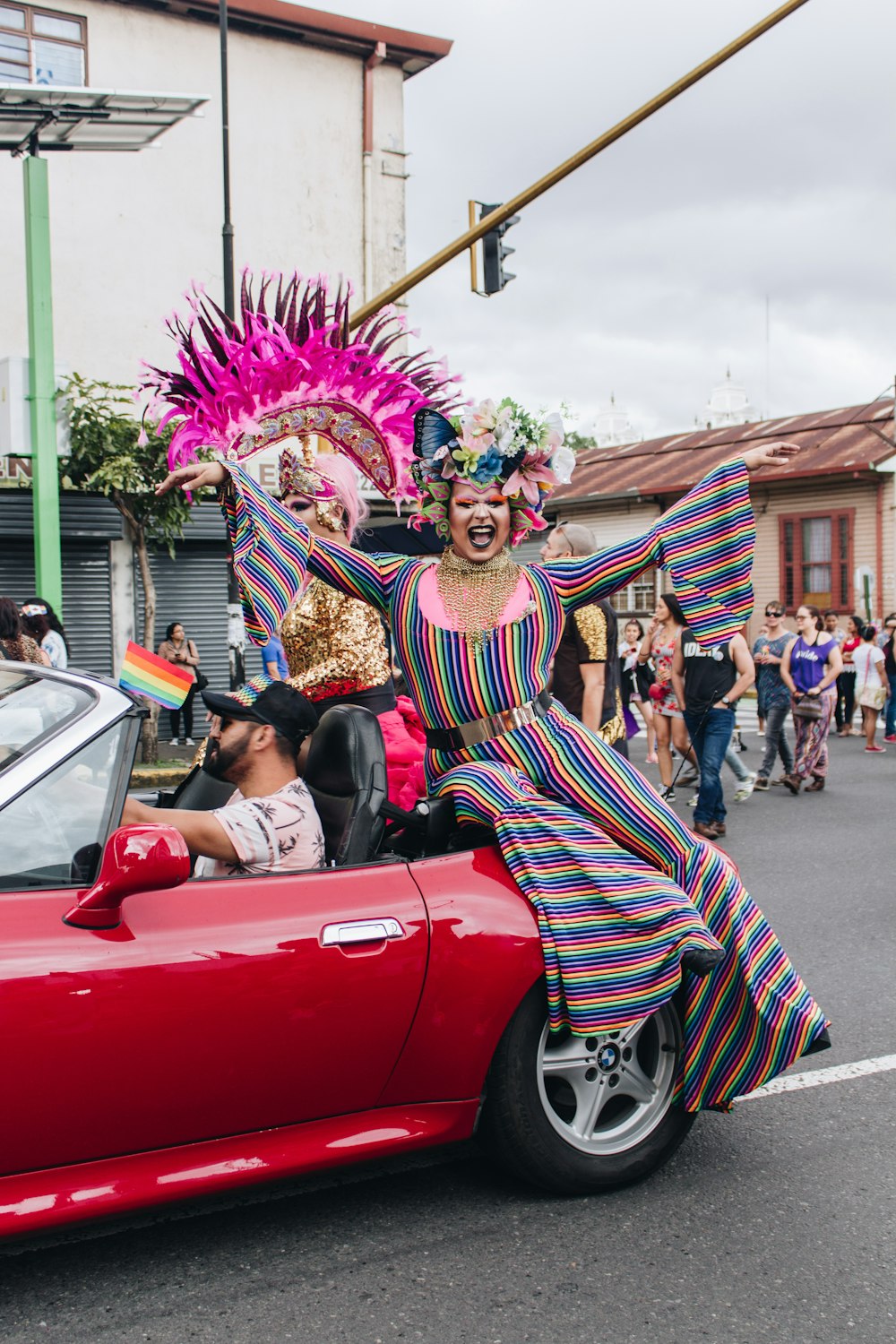 Mujer sentada en la parte superior de un cupé convertible rojo