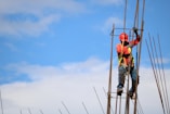 man wearing red hard hat hanged on brown rebar bar