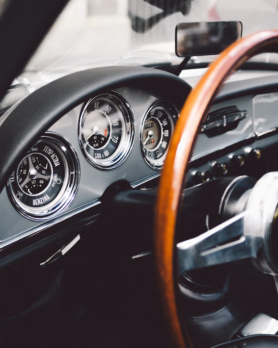 Wooden steering wheel and chrome dials of a classic car