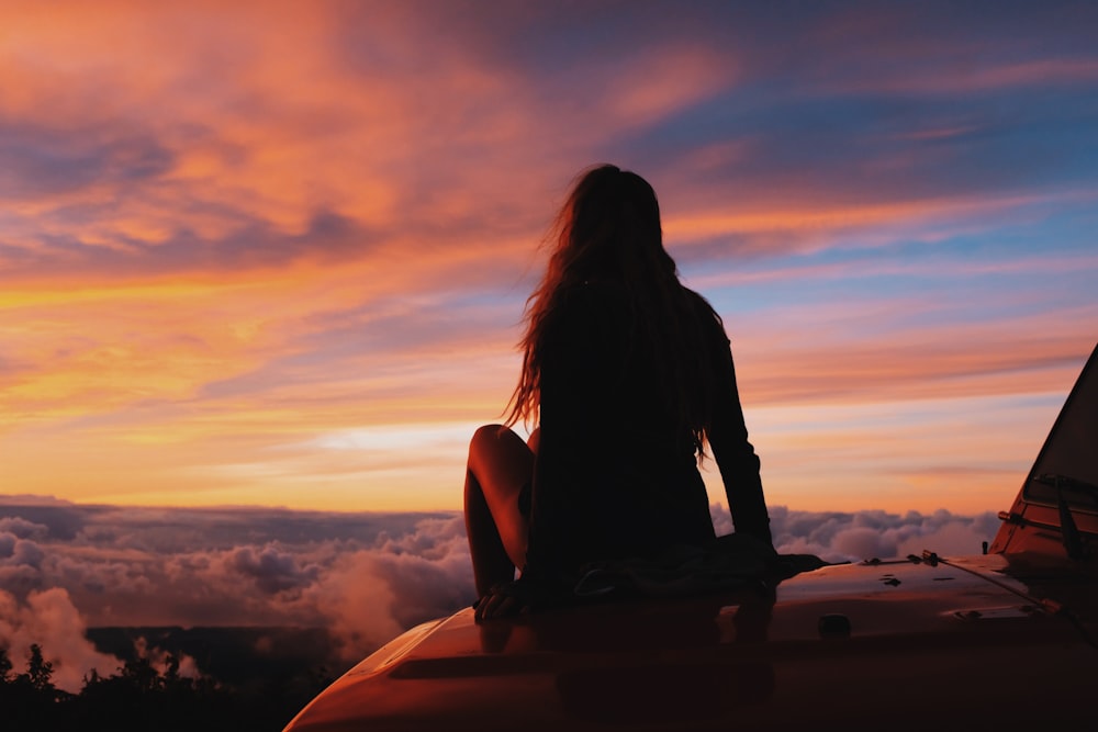 woman sitting on car