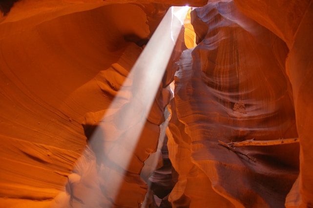A stunning sunbeam piercing through the narrow, wavy sandstone walls of Antelope Canyon.
