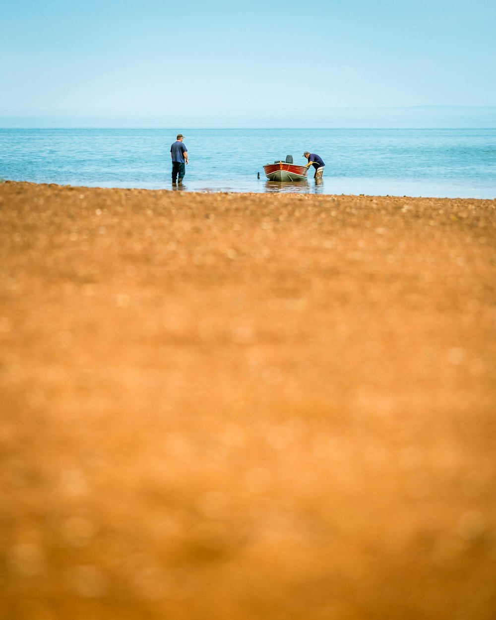 Dos hombres en el cuerpo de agua al lado del barco