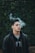 man smoking near green leaf trees