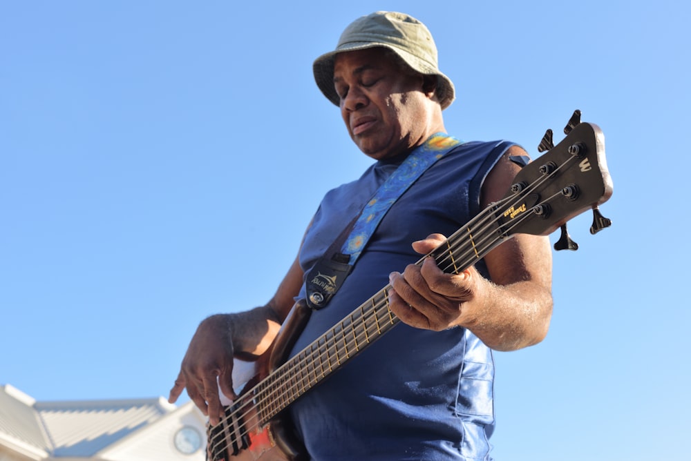 man playing electric bass guitar