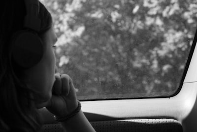 grayscale photo of woman inside car deeply thoughtful zoom background