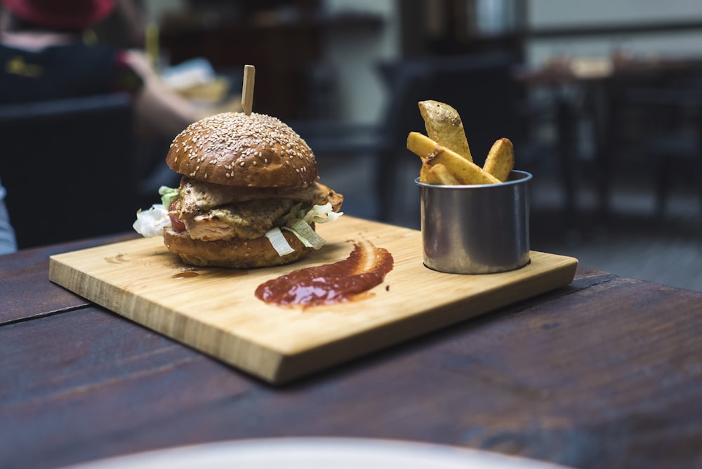 burger and fries on brown wooden tray