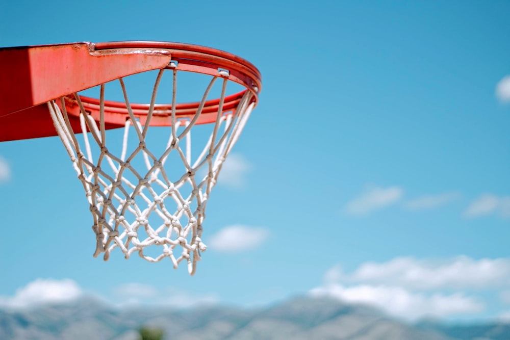 red basketball hoop with white net during daytime