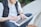 man using MacBook while sitting on bench