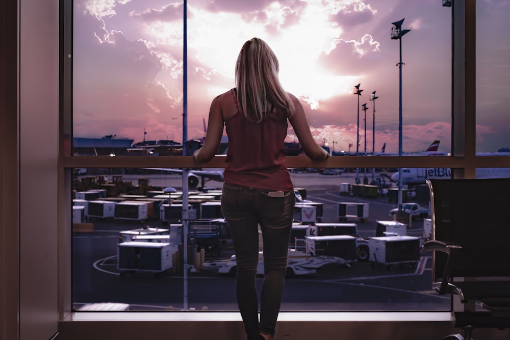 woman standing facing glass window